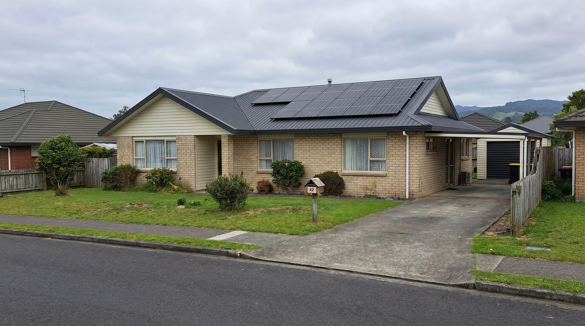 Solar panels on a Waikato weatherboard farmhouse with rolling green dairy hills behind